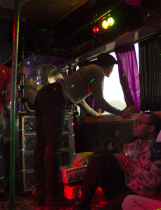 Darnell Thomas peeks out the window of the party bus while Terrance Sanders sits on the sidelines. Photo by Andrew Koss