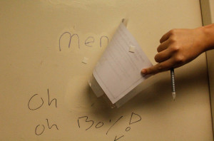 Covering the Men's sign on the gender neutral hall bathroom. Photo by Lauren Eubanks