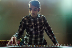 Saqeef Ali adjusting sound levels in O'Shaunasse Hall. Photo by Rebeca Gonzalez