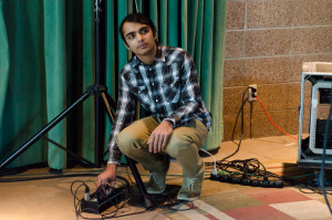 Saqeef Ali plugging in mic cords for a live performance. 