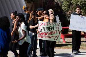 Nicole Sonobe displays her sign for student empowerment. Photo by Christy Marshall