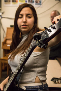 Jacinda tunes her bass before class. Photo By Christy Marshall