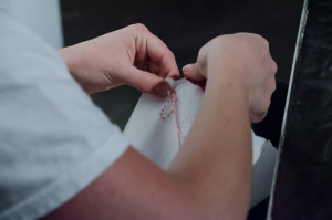 Ryan Robertson sews lettering onto paper panties. Photo by Rebeca Gonzalez