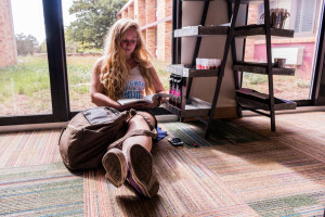 Freshmen Creative Writing August Edwards studying in between classes at Necessities. Photo by Yoana Medrano