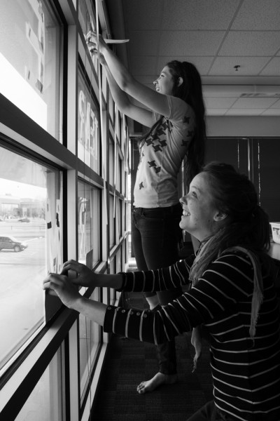 Arianna Sullivan (crouching) and Chelsea Alden (standing) prepare the final Snow Poem for painting with stencils. 