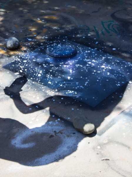 Kyleigh utilizes her gloved hands and white spray paint in order to create the illusion of flickering stars in the night sky.