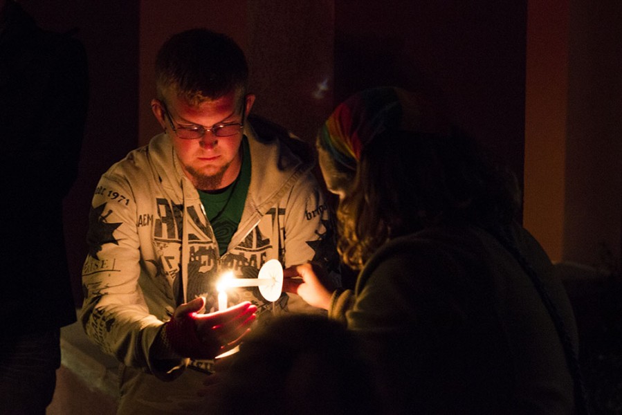 Cutlar Shell helps Cailin Kosman light her candle for the minute of silence. Photo by: Bego Aznar