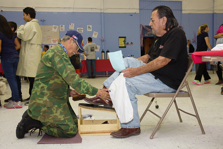 From right, Air Force Veteran Pedro Gonzales of Espanola gets a shoe shine from fellow Airmen Robert Bernal of Santa Fe during the Santa Fe Veterans Stand Down  on Friday October 24, 2014. Photo by Luke E. Montavon/The Jackalope