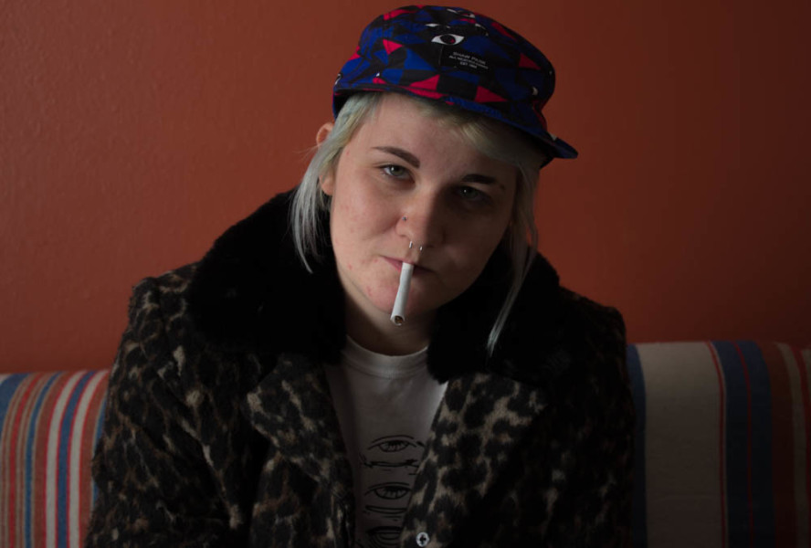 KT Collins, a film major in their junior year, sits in their apartment with a rolled cigarette. Photo by Kyleigh Carter.