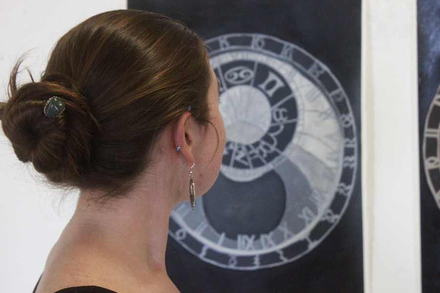 Hannah Gardner looking at her triptych series depicting the Prague astronomical clock. Photo by Andrew Koss