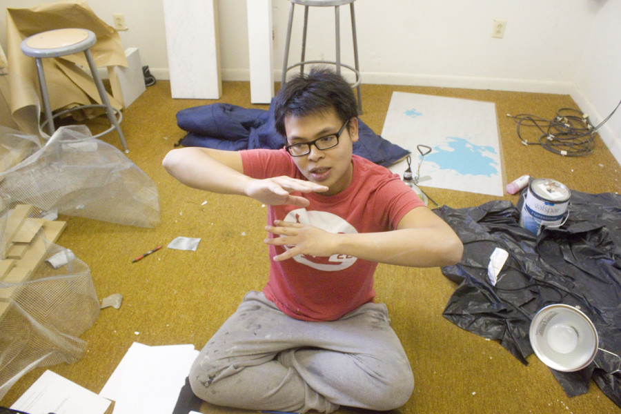 Junior Studio Arts major Phat Le explains his artistic process amid the clutter of his studio in the barracks. Photo by Andrew Koss