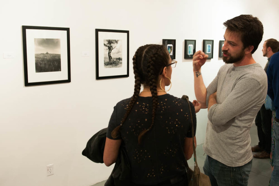 Andrew Coleman discusses his work with a fellow member of the Stangers Collective. Photo By Forrest Soper.