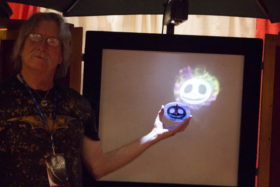 Richard Elvis displays how light affects the ornamental glass pieces he sells. Photo by Christy Marshall