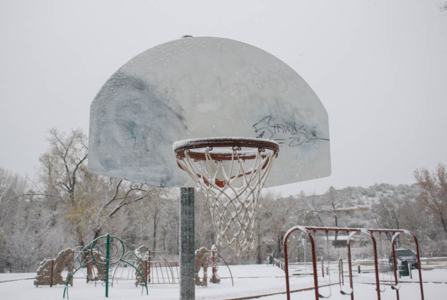 A frozen basketball hoop at an empty park. Photo by Kyleigh Carter.