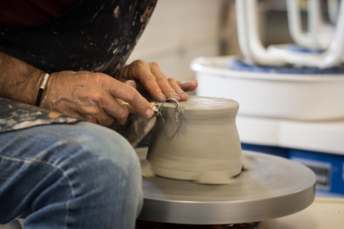 Edging the bowl on the pottery wheel. Photo by Jason Stilgebouer