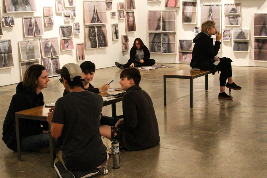 Isaac Leigh, Chris Castellanos, Madeleine Sardina,Brianna Neumann, Anna Holland and Sophie Farrell sit in Ann Hamilton’s exhibit taking notes and discussing the pieces they decide to write about . Photo by Christy Marshall 