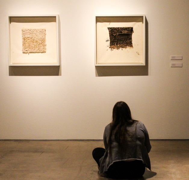 Jennie Clements sits taking notes on other pieces by Leonardo Drew. Photo by Christy Marshall