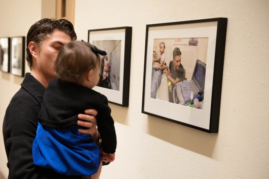 Ramon Sena and his daughter, the primary subjects of Podio’s thesis, view photographs of themselves at the Marion Center. Photo by Forrest Soper.