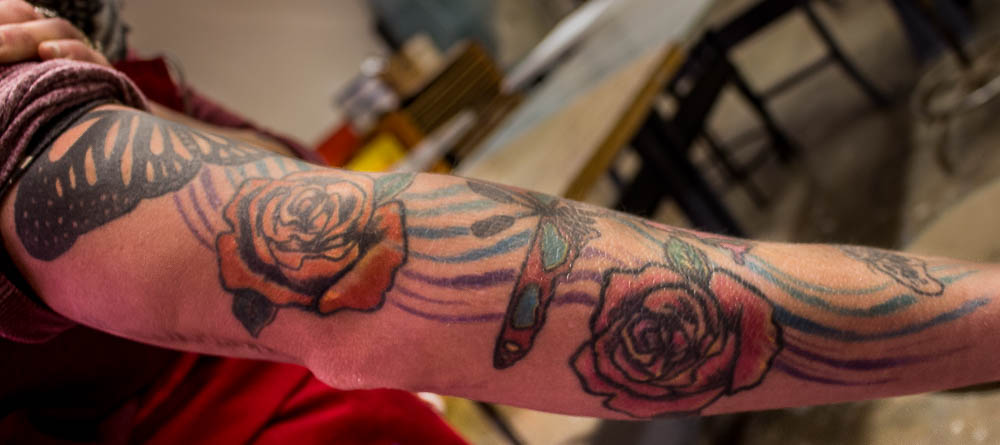 Hana Patrick shows her tattoo of roses and butterflies in the studio arts building. Photo by Christy Marshall 