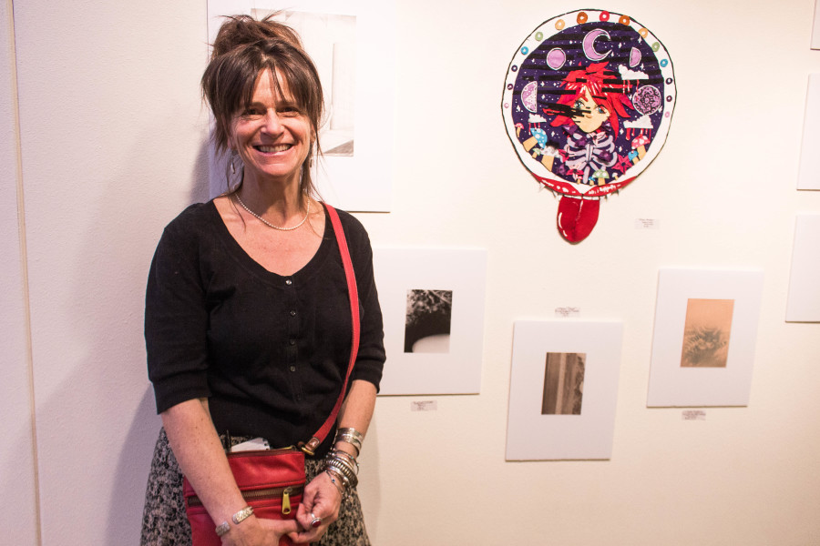 Nancy Michels stands next to a student’s work at the Monte del Sol exhibit held annually at the Marion Center.