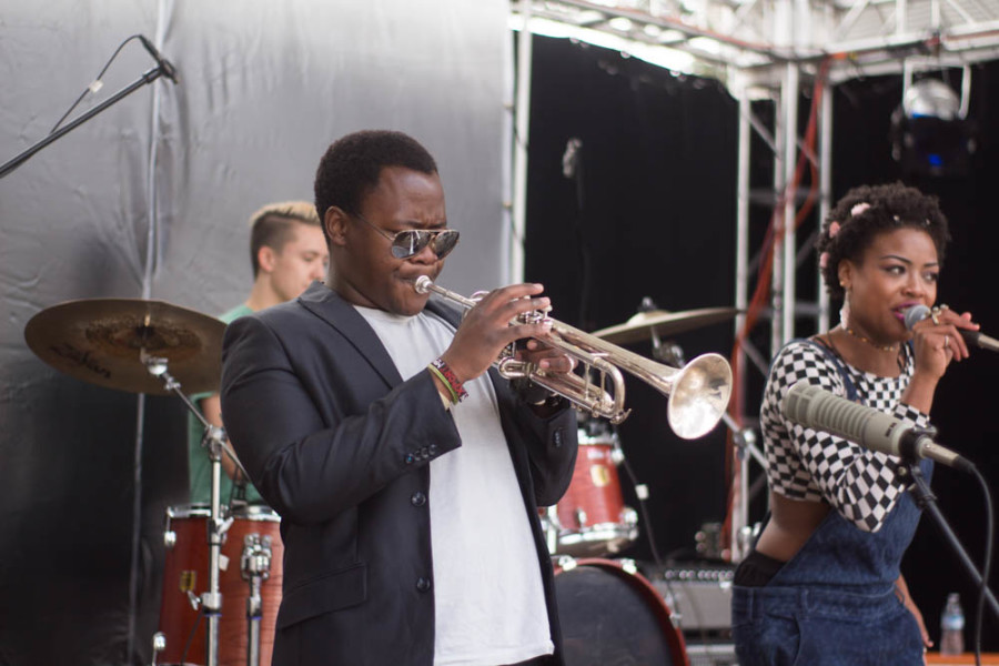 Ardaya’s trumpet player Njaveva Bingana performs along side band members at Quadstock. Photo by Jason Stilgebouer.