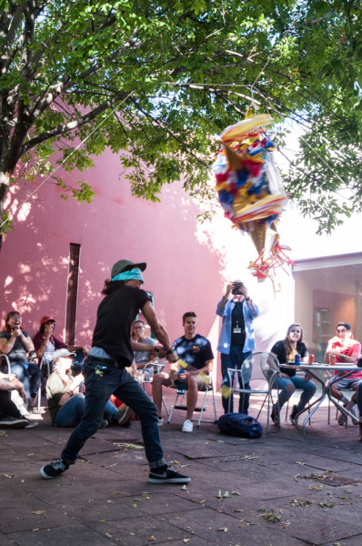 Freshman Photographer Richard Sweeting is practicing his swing on the pinata during the department barbecue. Photo by Sasha Hill