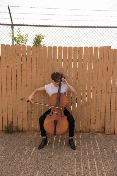 Lara White practices their cello harmonics publicly. Photo by Kaitlyn Sims.