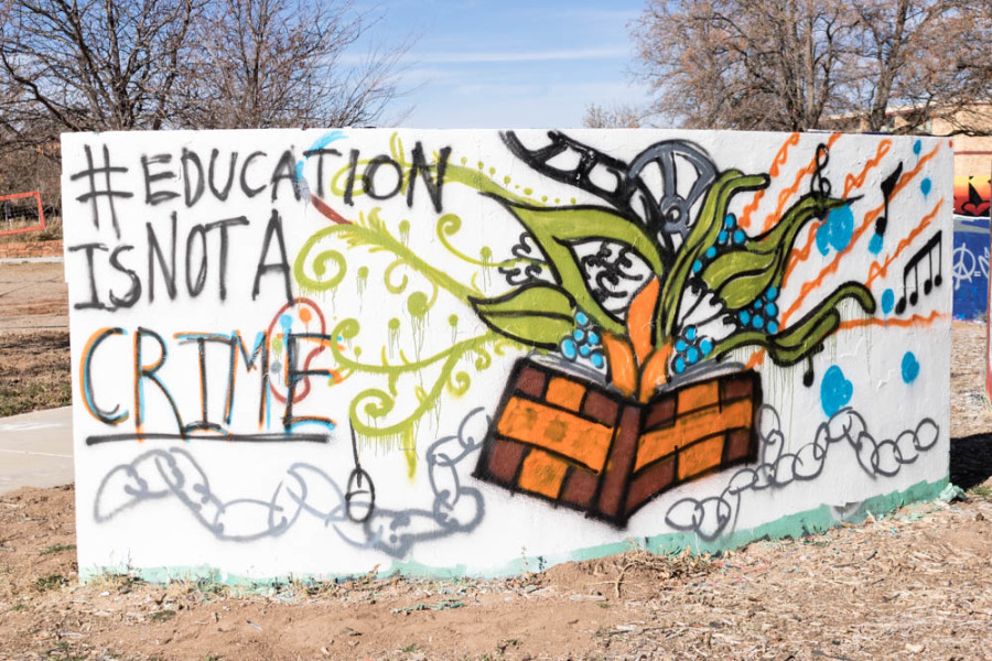 Student presents #EducationIsNotACrime mural on graffiti walls. Photo by Kaitlyn Sims.