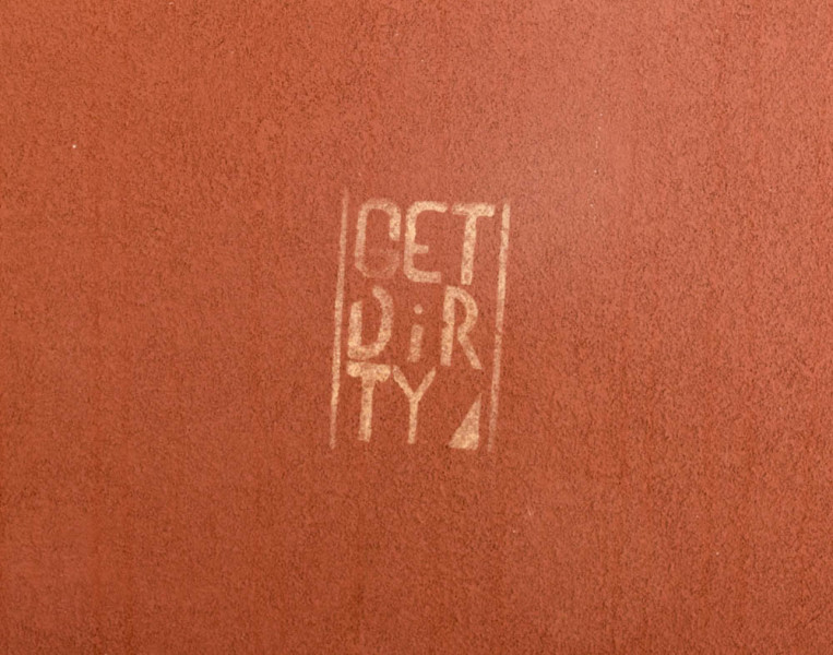 “Get Dirty” spray painted onto wall near Kennedy Hall and the food trucks. Photo by Kaitlyn Sims.