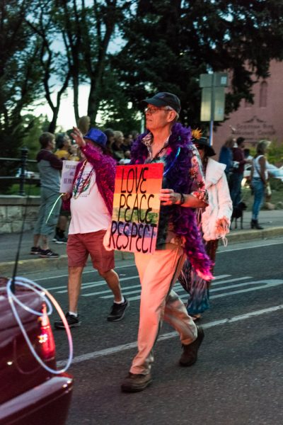 Parade participant walking with sign. Photo by Sasha Hill