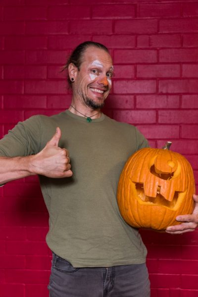 Raymond Davis enthusiastically poses with his carved pumpkin. Photo by Sasha HIll