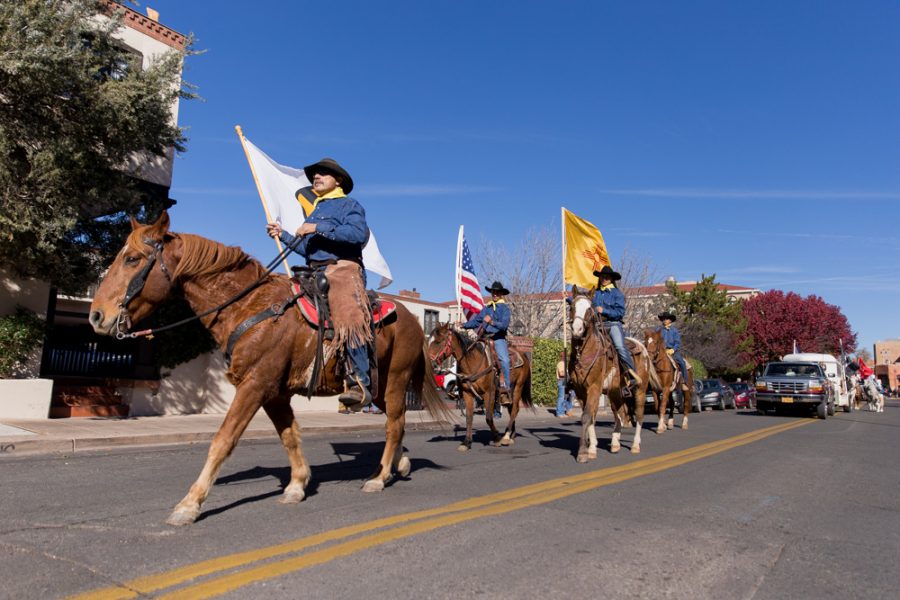 Santa Fe High School’s Rodeo Club trots down Don Gaspar Avenue honoring veterans during the annual Veterans Day parade. Photo by Jason Stilgebouer