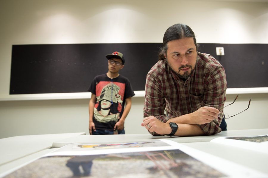 Photography teacher Chris Nail reviews Matthew Anderson’s thesis in detail during the Santa Fe University of Art and Design Photography Department salon. Photo by Jason Stilgebouer